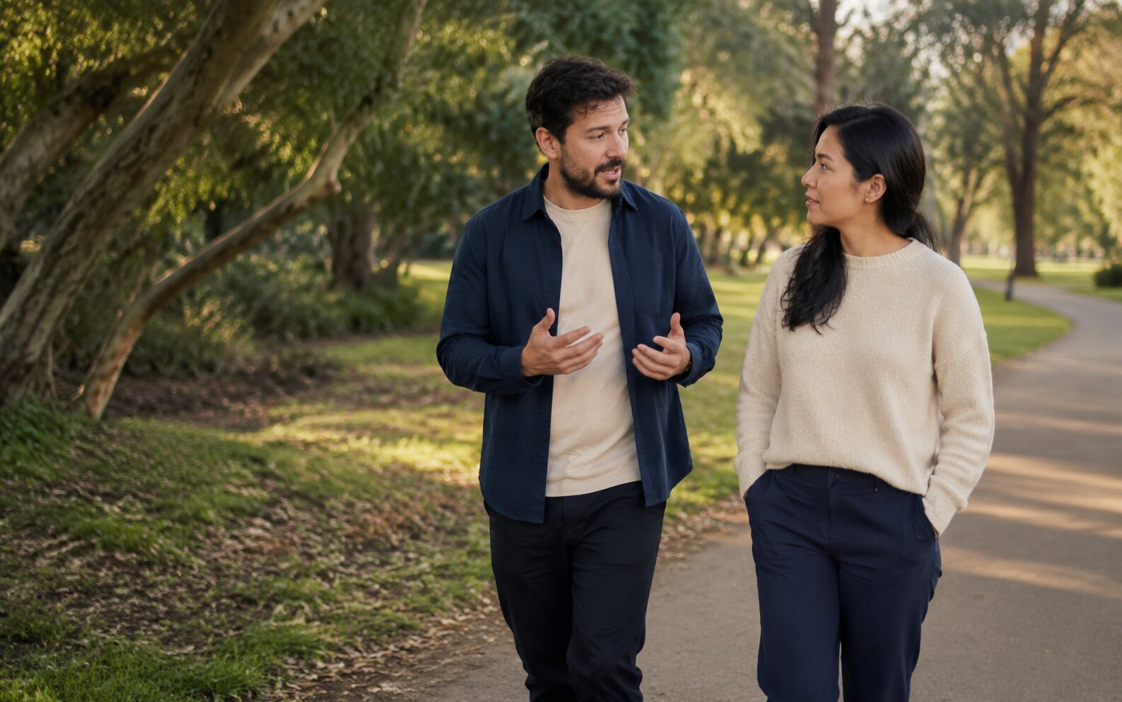 Two adults sharing a calm mental health support check-in while walking through a leafy Melbourne park
