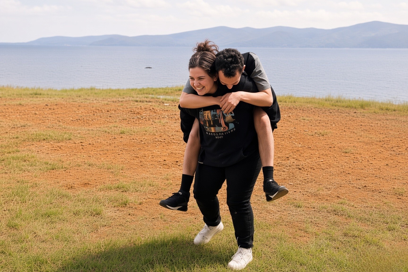 Two people sharing a joyful moment outdoors beside the water